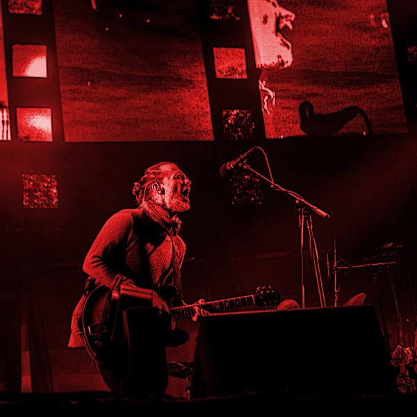 Stained red photograph of Thom Yorke performing onstage