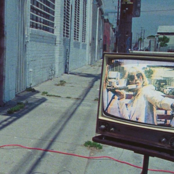 Promotional image of St. Vincent showing her on an old TV set in the street