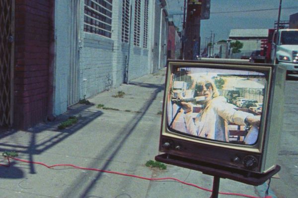 Promotional image of St. Vincent showing her on an old TV set in the street